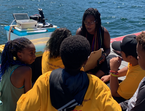 Dr. Dijanna Figueroa working with young students on a boat