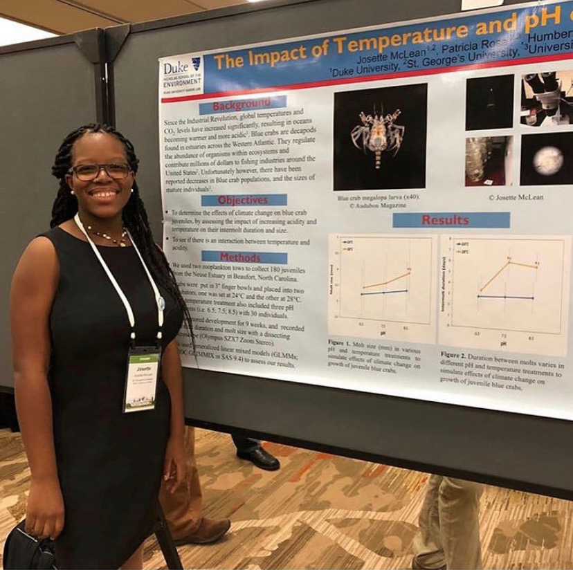 Josette stands in front of her scientific poster