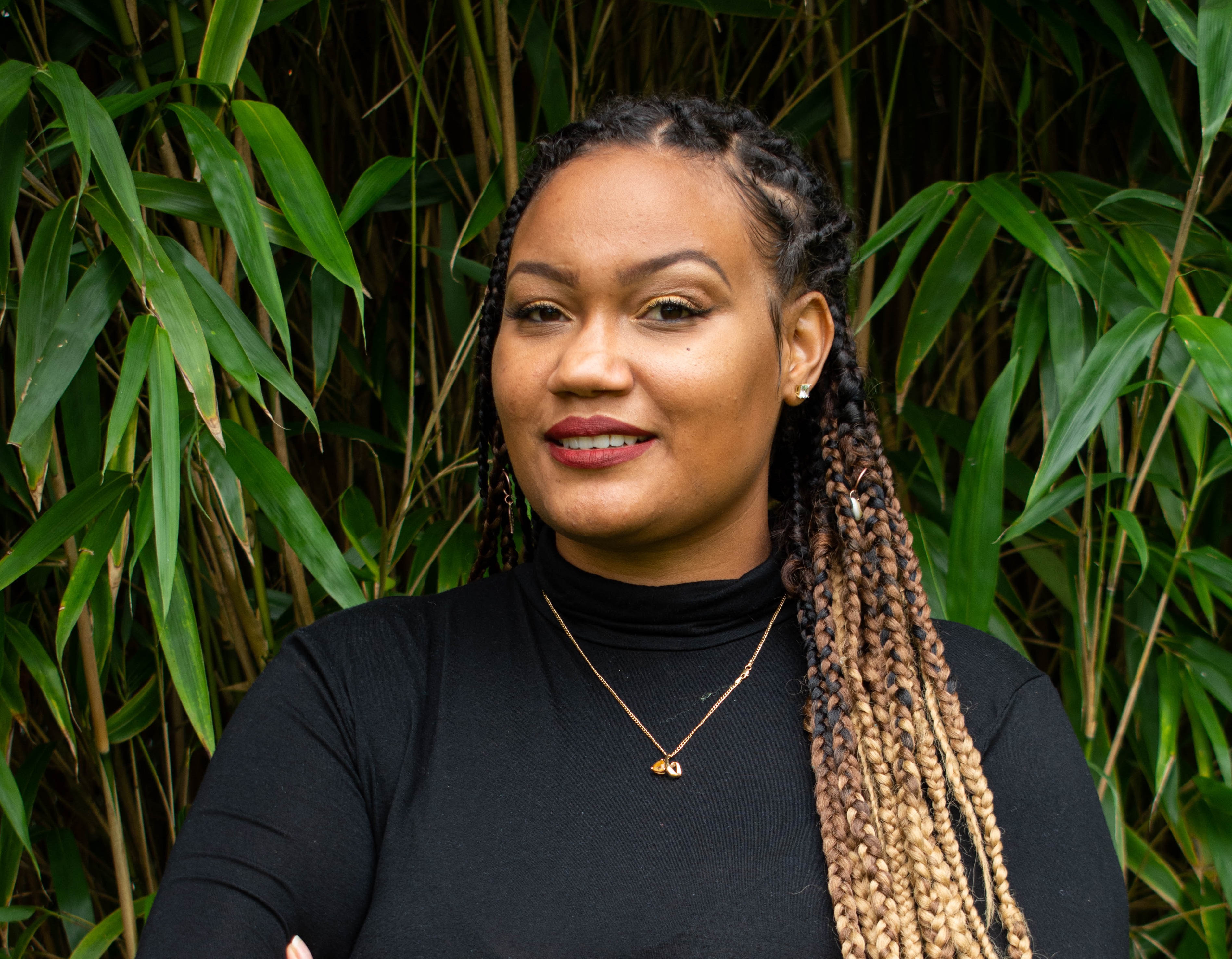 Lashanti Jupp smiling and leaning into some greenery