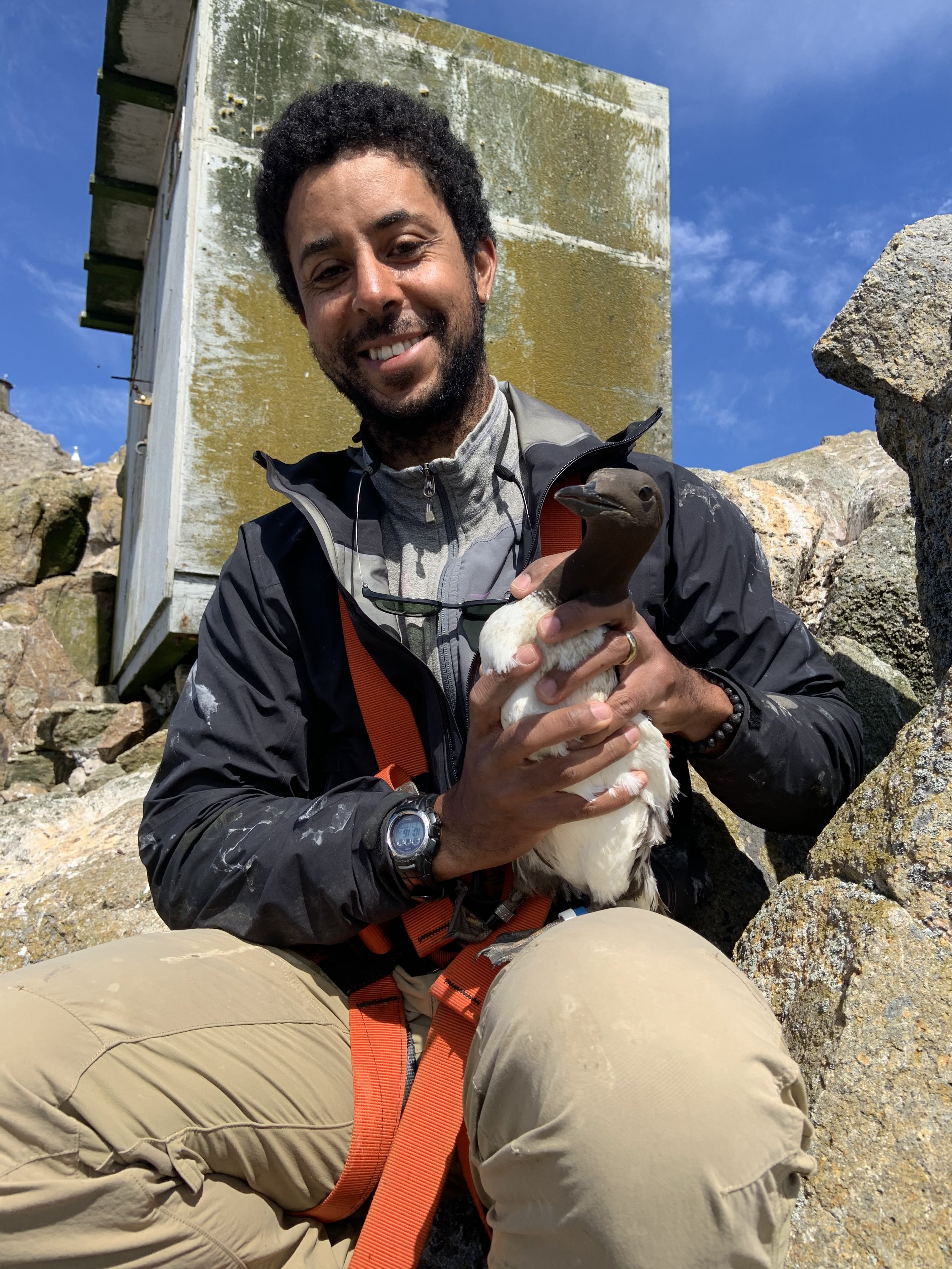 Sean holds a bird outdoors